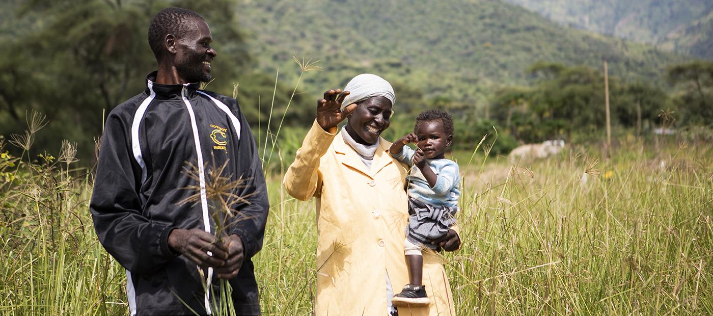 A happy family stands in a field